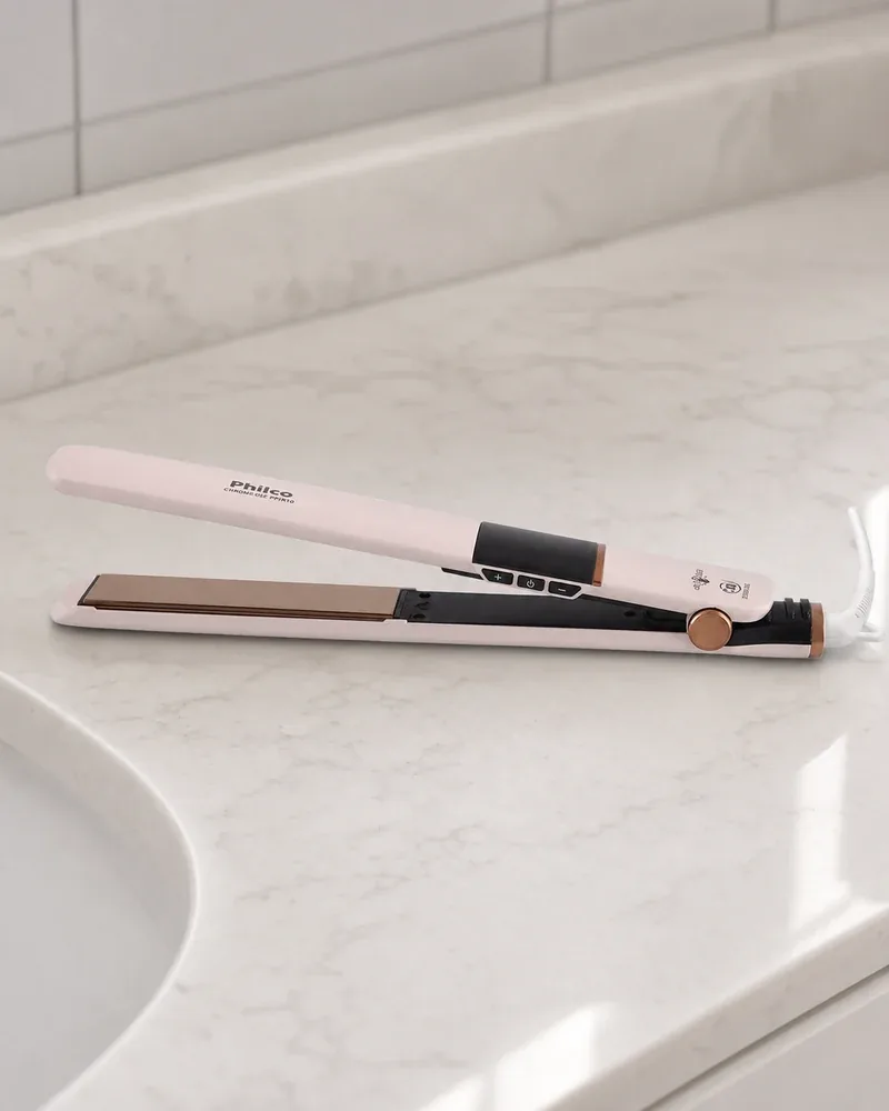Prancha Philco PPR10 rosa-clara, aberta, na bancada de mármore branco perto da pia